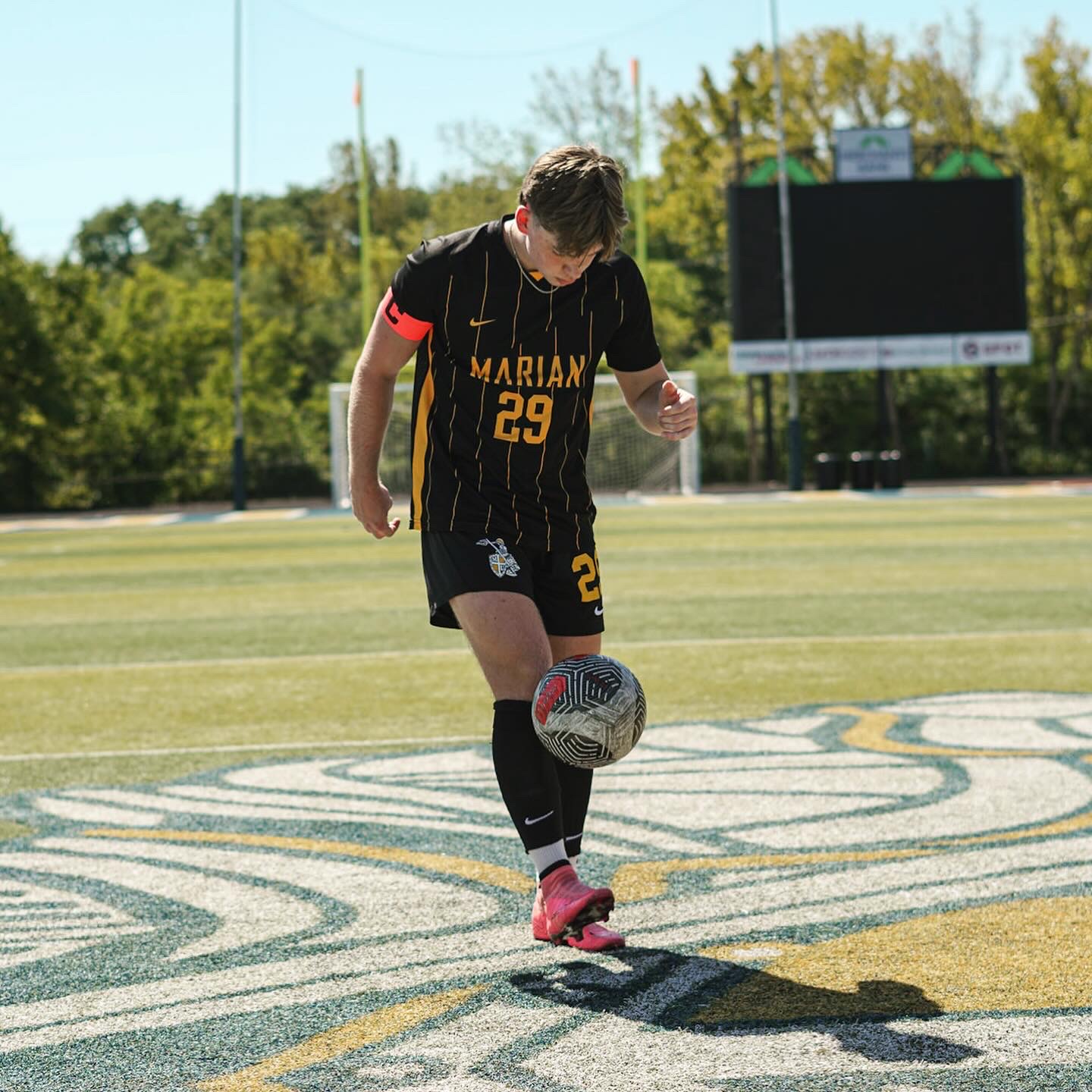 Jackson playing for Marian University soccer, wearing the captain's armband